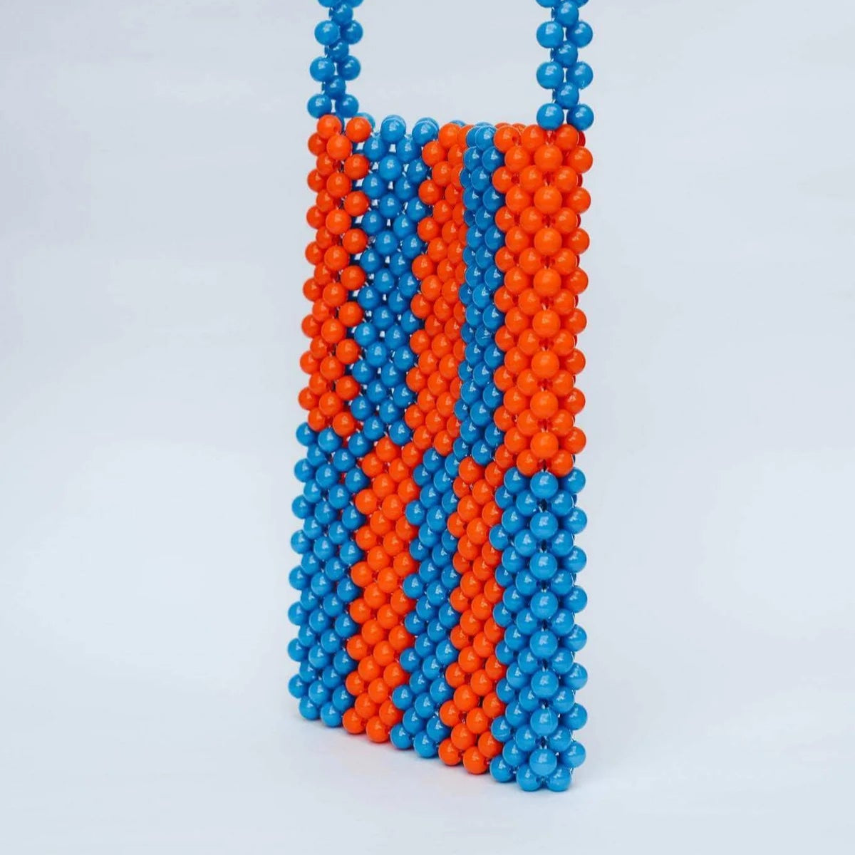 Necklace with blue and orange beads on a light gray background