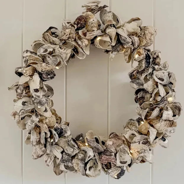 Shell Oyster Christmas wreath hanging on a white timber wall