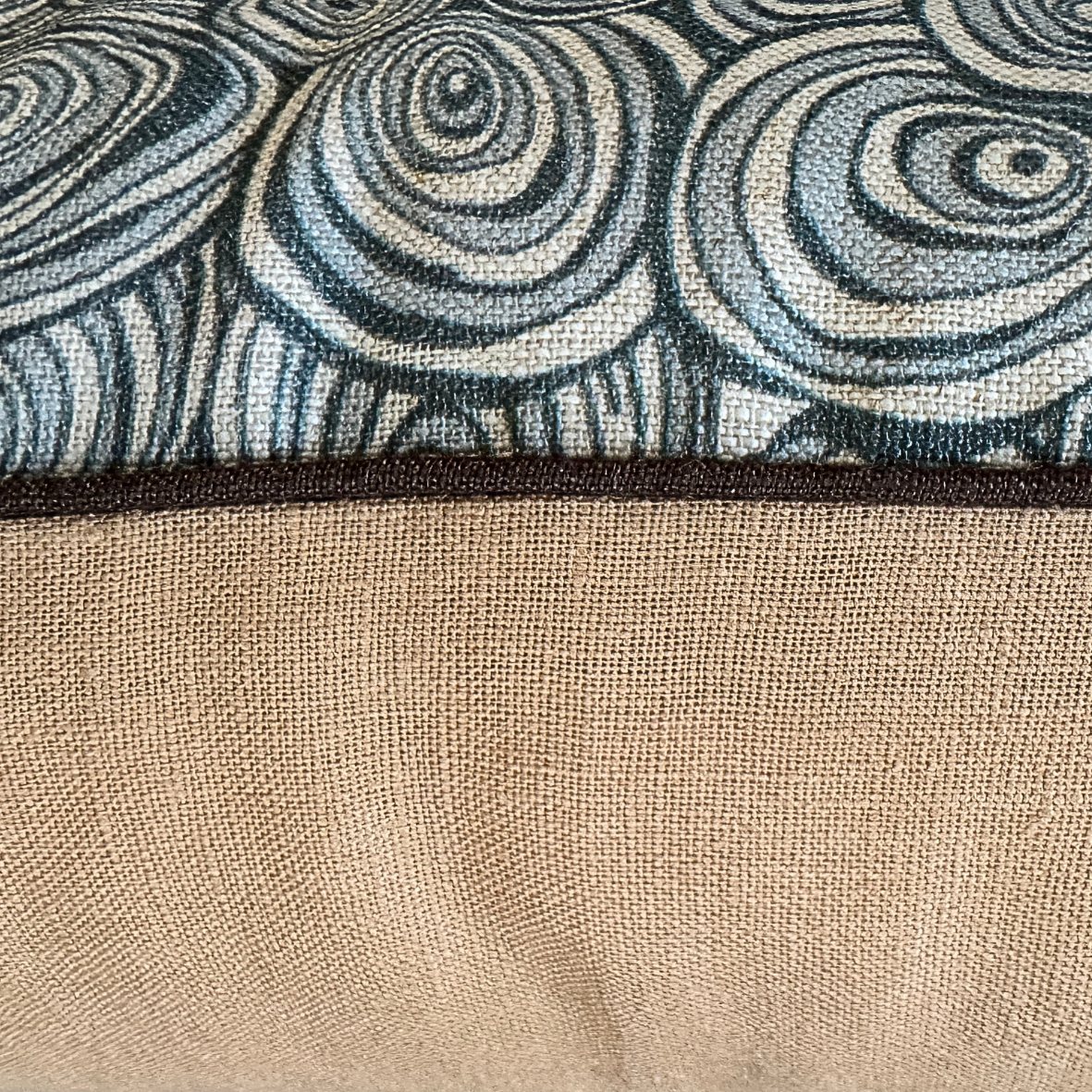Close-up of Frenchmans Growth Rings linen cushion showing printed front, natural linen back and dark piping