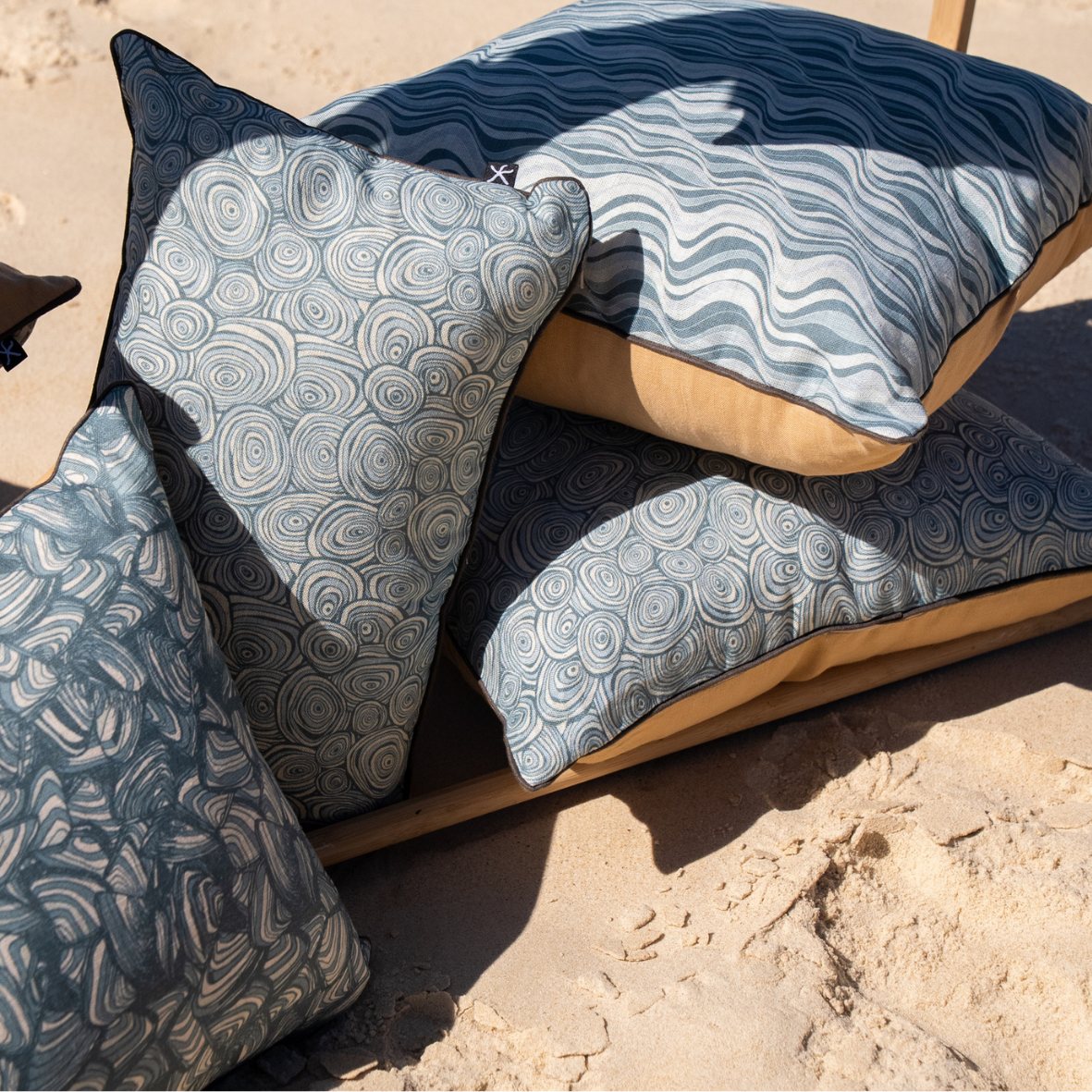 Frenchmans Growth Rings linen cushion covers styled with coordinating coastal cushions on a beach lounger