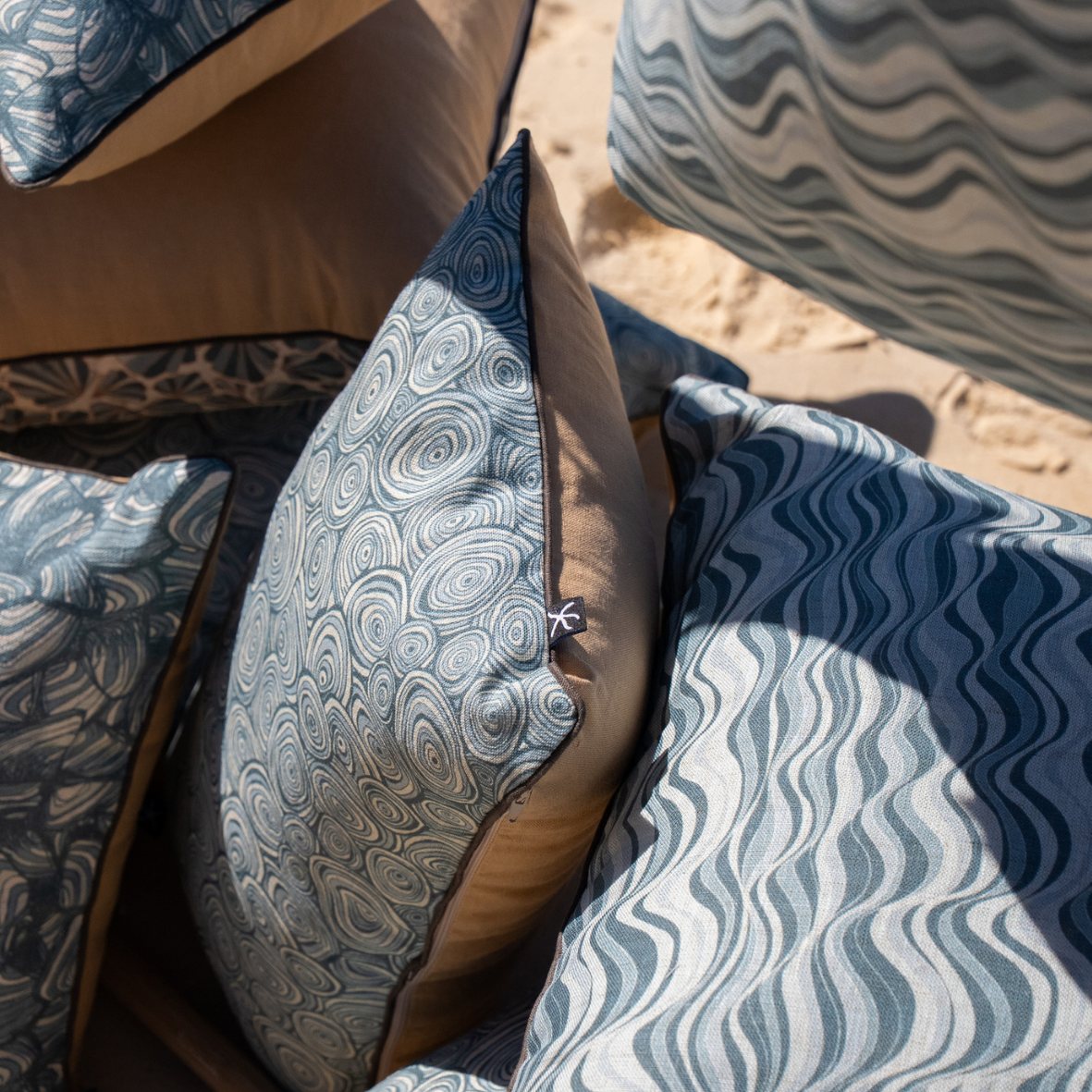 Frenchmans Growth Rings linen cushion shown from the side with coordinating blue coastal cushion designs