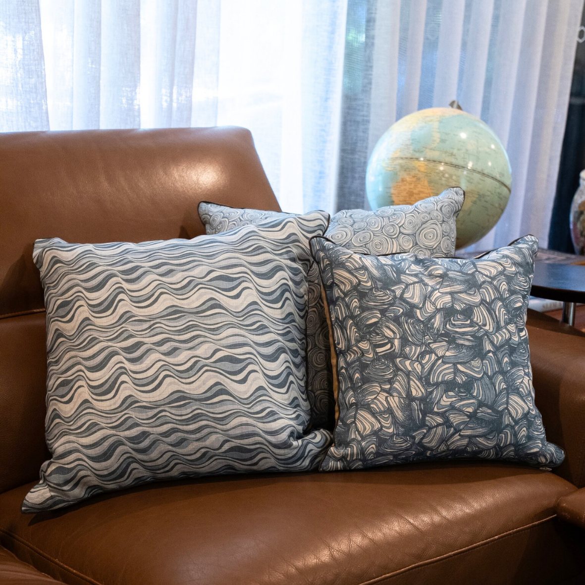 Frenchmans linen cushion covers in Growth Rings, Pipi and Straddie Stripe styled on a brown leather sofa