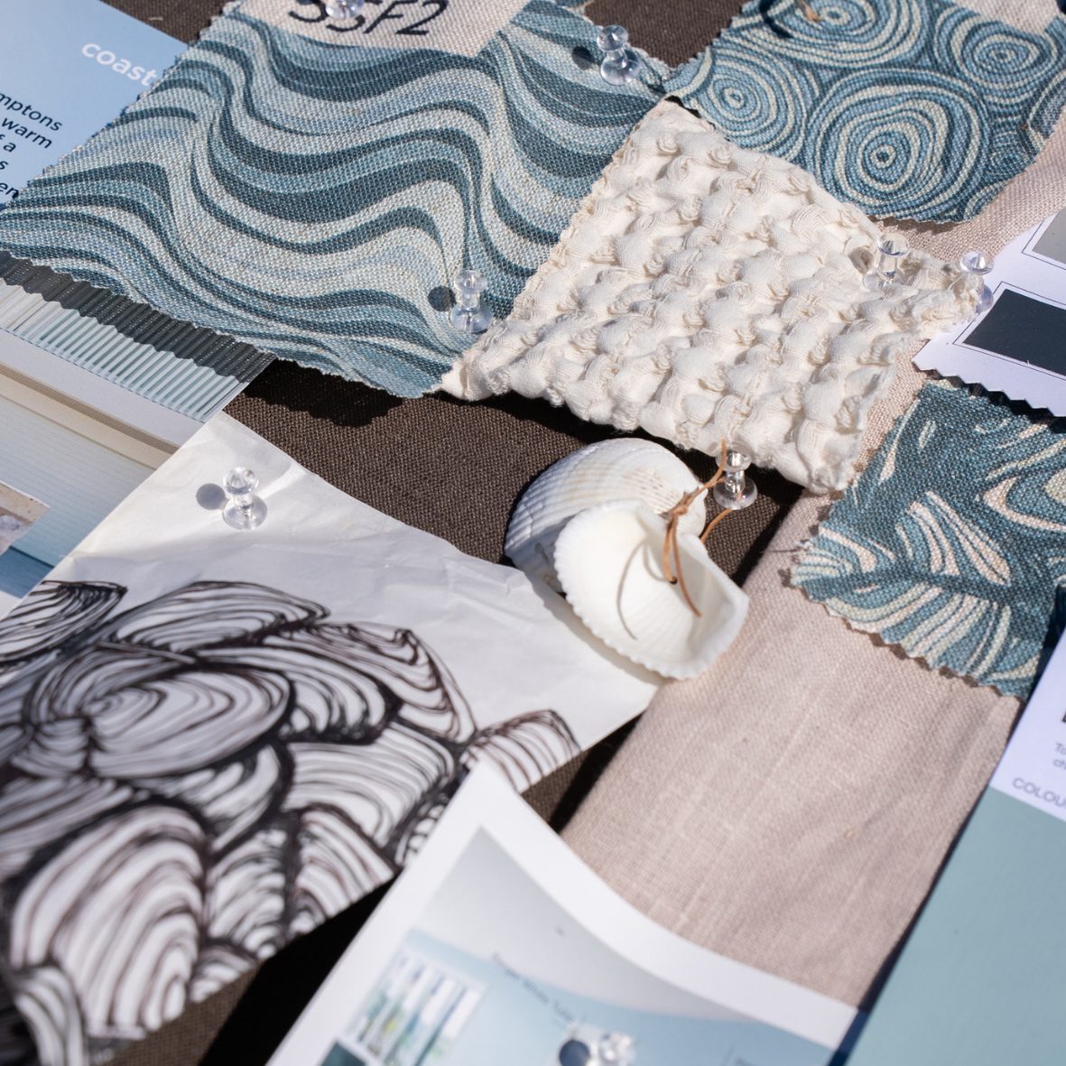 Detailed close-up of the Frenchmans Pipi mood board with fabric swatches, shell accents and design sketch.