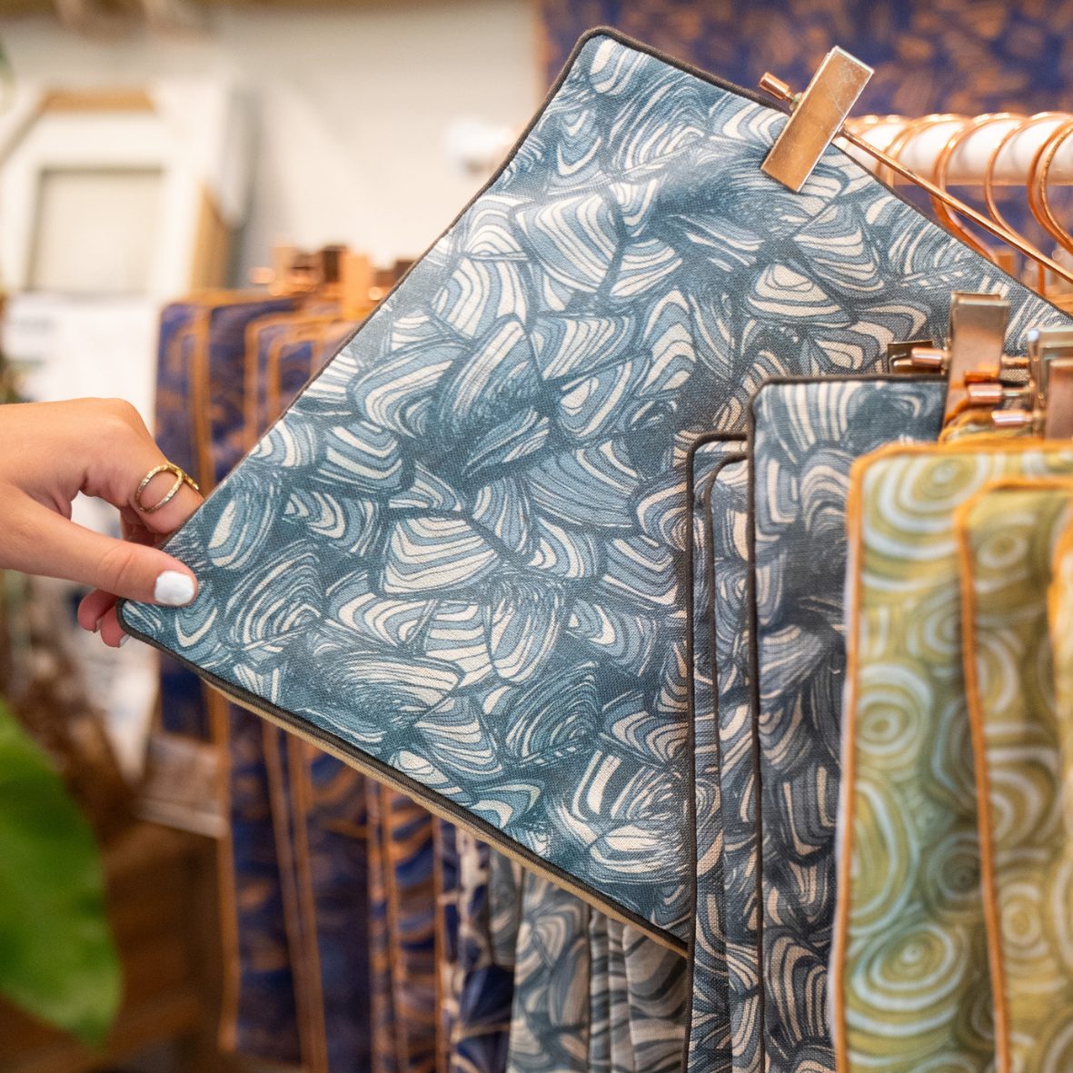 Frenchmans Pipi linen cushion covers displayed on a retail rack in store.