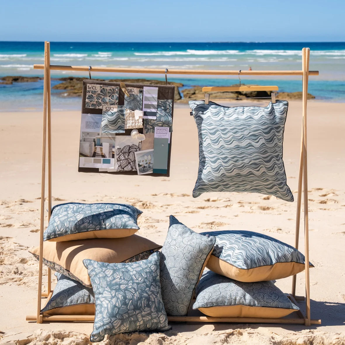Frenchmans Straddie Stripe cushion displayed with the collection moodboard on a beach rack.