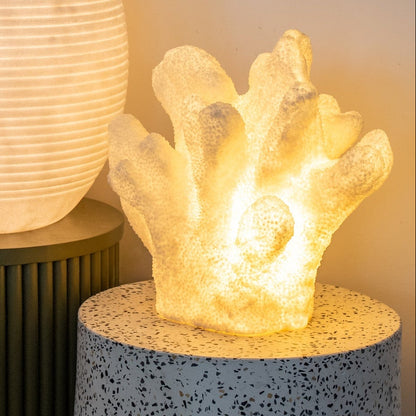 Decorative lamp shaped like a coral on a speckled surface with a soft light.