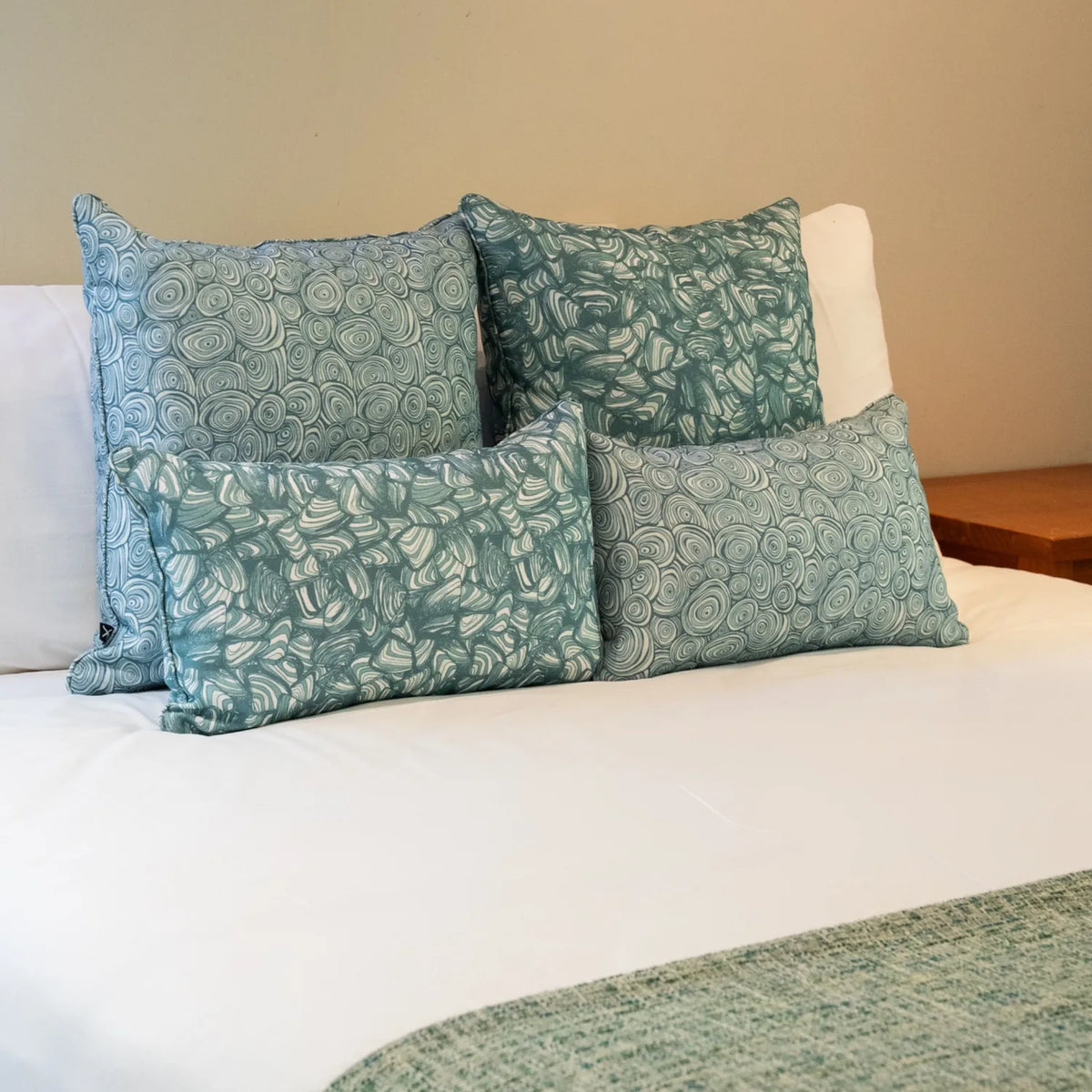 Bedroom styling with Frenchmans colourway cushions featuring both the Pipi and Growth Rings patterns in square and lumbar sizes.